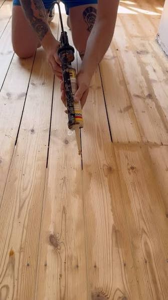 Cracked and lifted gap filler between wide Baltic Pine floorboards