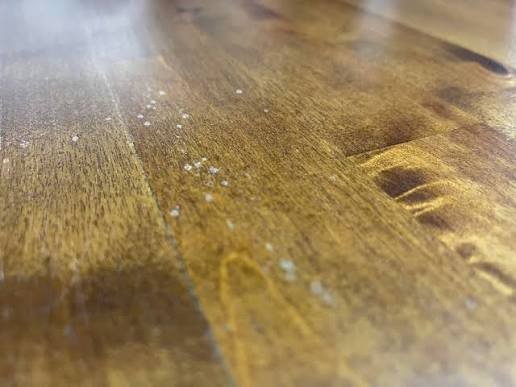Dark tannin bleed staining showing through a clear finish on a hardwood floor