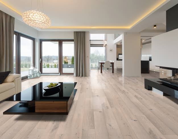 A wide pale limed-oak floor running through an open-plan living and dining room